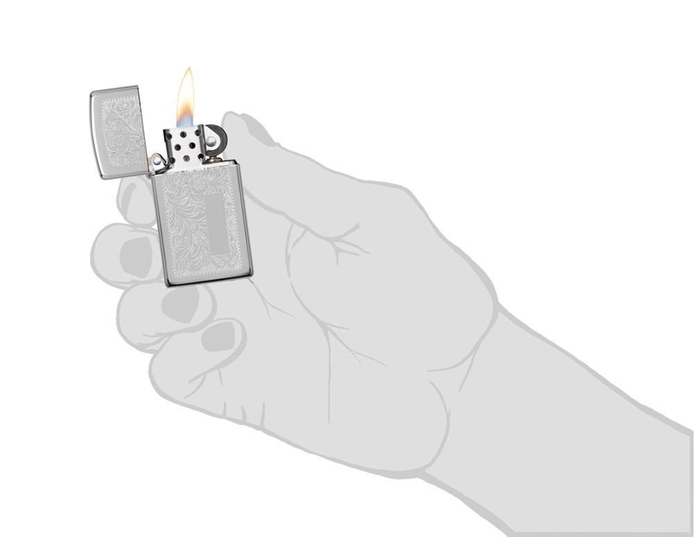 Frontansicht Zippo Feuerzeug Slim Chrome Venezianisches Blumenmuster mit Initialplatte geöffnet mit Feuer in stilistischer Hand