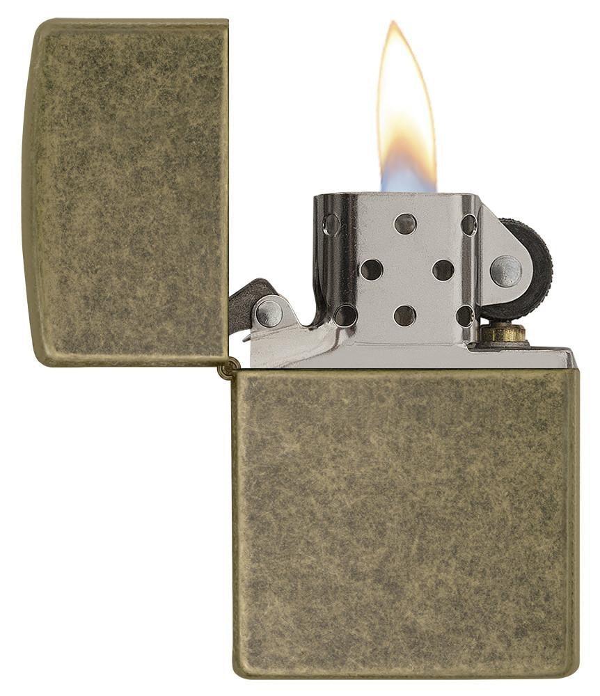 Ein offenes Zippo-Feuerzeug mit brennender Flamme zeigt sein metallisches, perforiertes Innenleben vor einem neutralen Hintergrund.