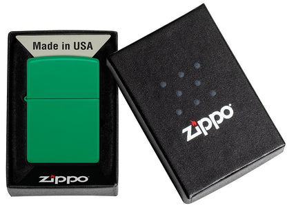 Ein grünes Zippo-Feuerzeug liegt in einer schwarzen Box mit der Aufschrift "Made in USA" und dem Zippo-Logo, dargestellt in einem schlichten Präsentationsdesign.