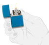 Zippo Feuerzeug Basismodell Sapphire blau Hochglanz geöffnet mit Flamme in stilisierter Hand