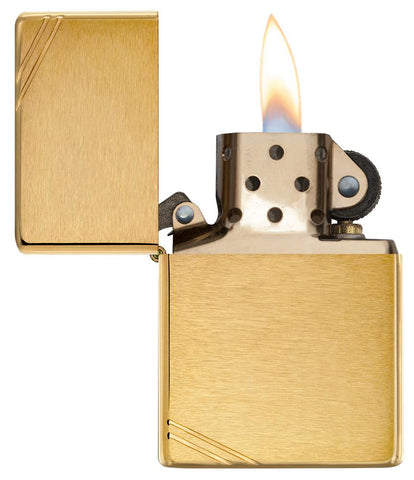 Frontansicht Zippo Feuerzeug Vintage Brass Brushed mit dekorativen Schrägstrichen an beiden Ecken geöffnet mit Flamme