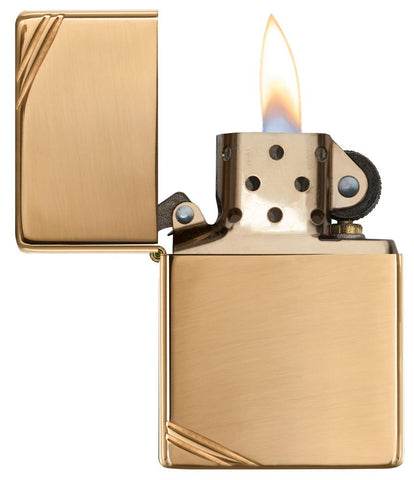 Frontansicht Zippo Feuerzeug Vintage Brass High Polished mit dekorativen Schrägstrichen an beiden Ecken geöffnet mit Flamme