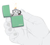 Zippo Feuerzeug Basismodell Chameleon mit Logo Grün poliert geöffnet mit Flamme in stilisierter Hand