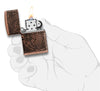 Frontansicht Zippo Feuerzeug Armor Antique Copper Multi Cut mit Weltkarte eingraviert geöffnet mit Flamme in stilisierter Hand