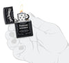 Frontansicht  Zippo Feuerzeug schwarz matt mit Jack Daniel's Logo geöffnet mit Flamme in stilistischer Hand