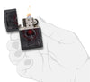 Zippo Feuerzeug Frontansicht geöffnet und angezündet mit gothic inspiriertem Pik-Ass Spielkarten Motiv in dunkelrot und schwarz in stilisierter Hand
