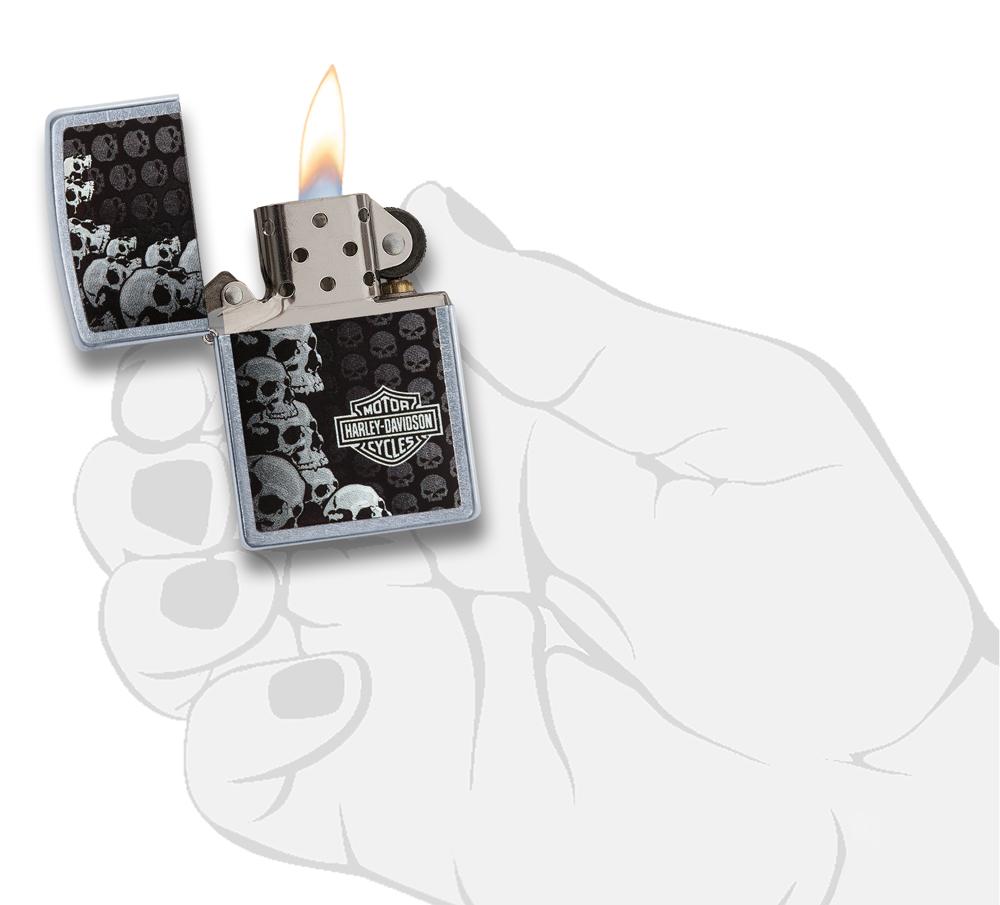 Zippo Feuerzeug Harley-Davidson Logo umgeben von Totenköpfen in verschiedenen Größen geöffnet mit Flamme in stilisierter Hand